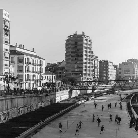 Urban environment with apartment buildings and a pedestrian bridge in Málaga. Young people playing volleyball